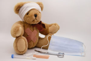 a teddy bear with bandaged head and a mask